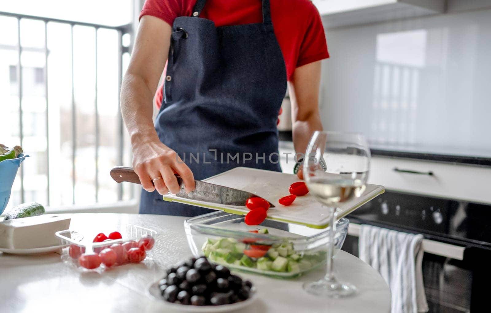 Girl Pours Chopped Cherry Tomatoes Into Bowl by tan4ikk1