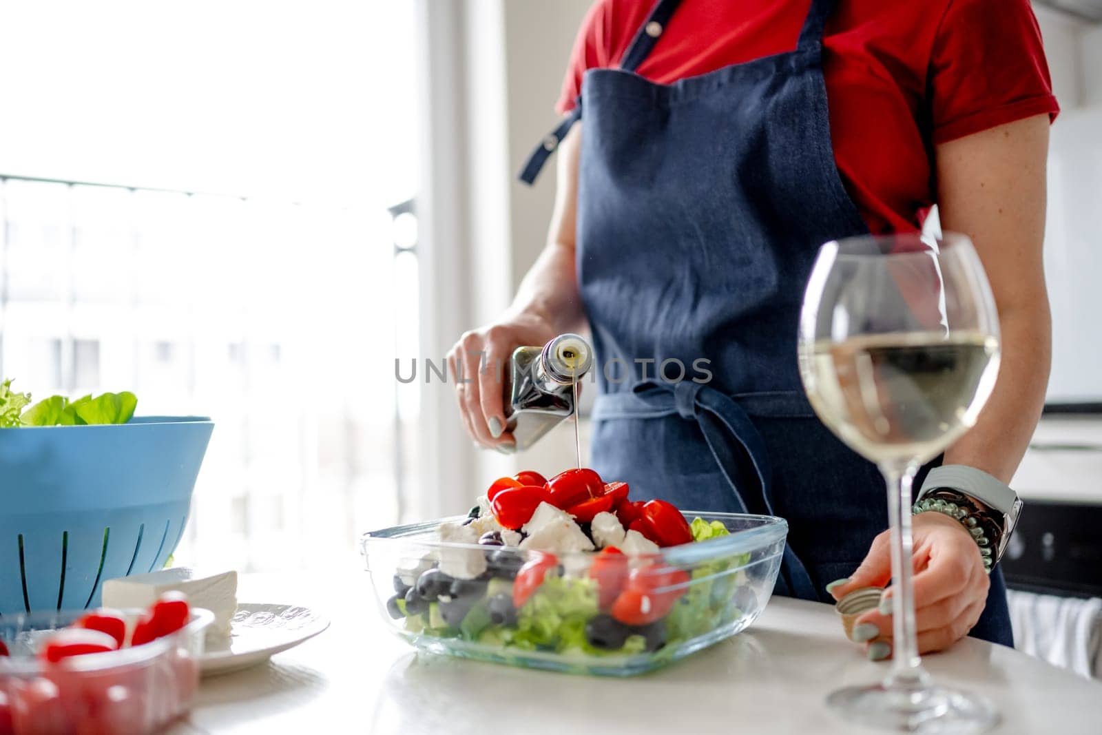 Female Hands Drizzle Oil On Greek Salad. Delicious Vegetarian Meal