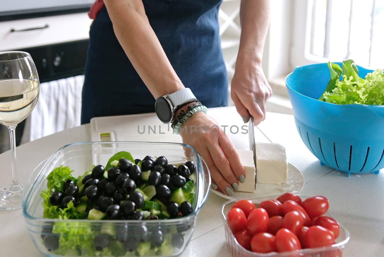 Girl Cuts Feta Cheese For Greek Salad, Preparing Food At Home In Kitchen