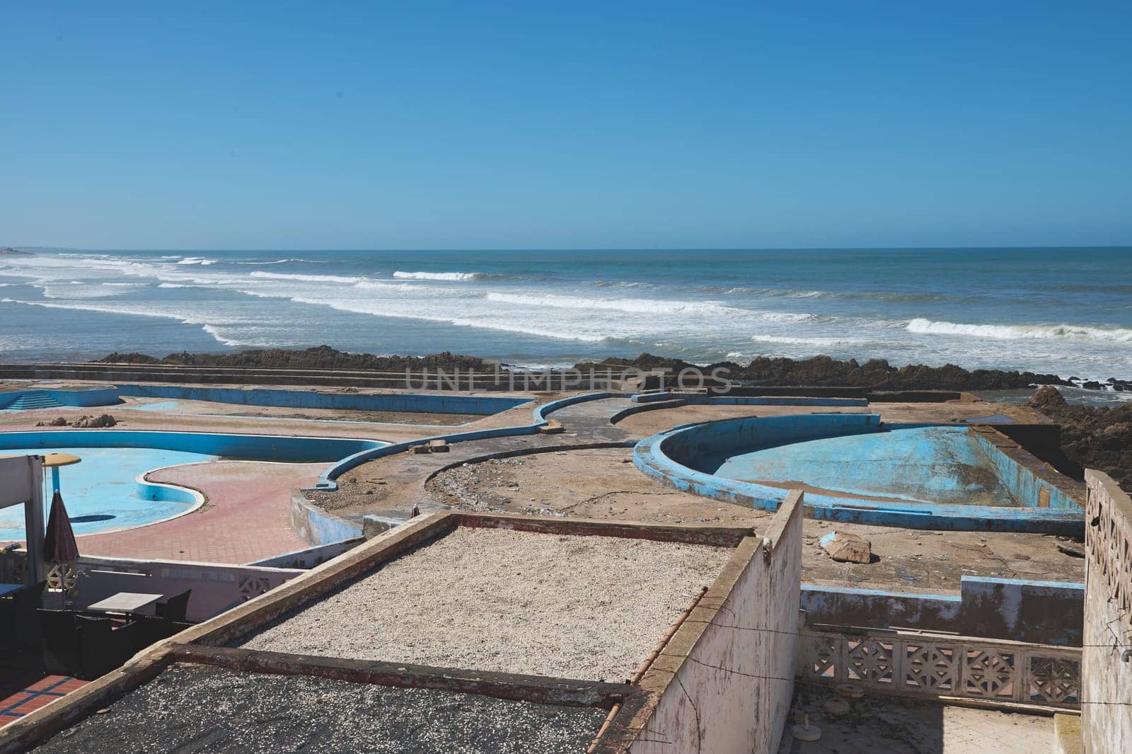 Abandoned swimming pool on the rooftop in Casablanca city, Atlantic beach on the background by artgf