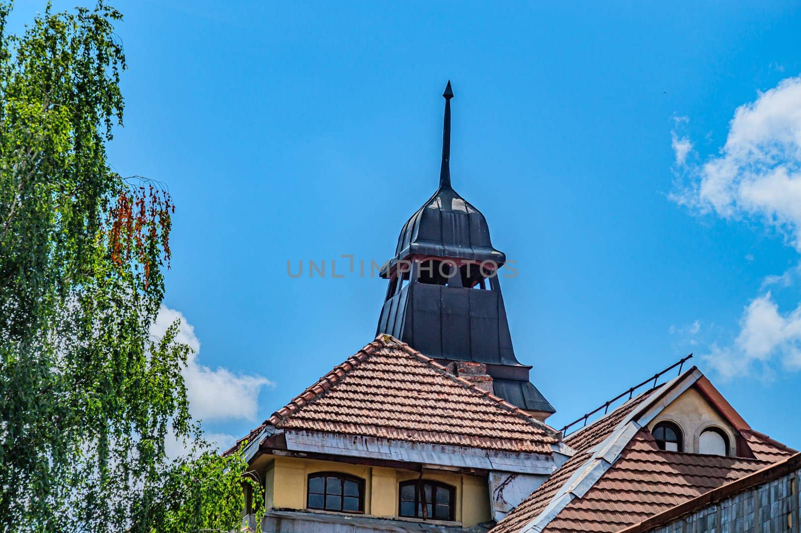 An ancient Gothic tower. A black tower with a tip, a place for archers, for defense under blue sky. Kharkiv Ukraine 05-05-2023