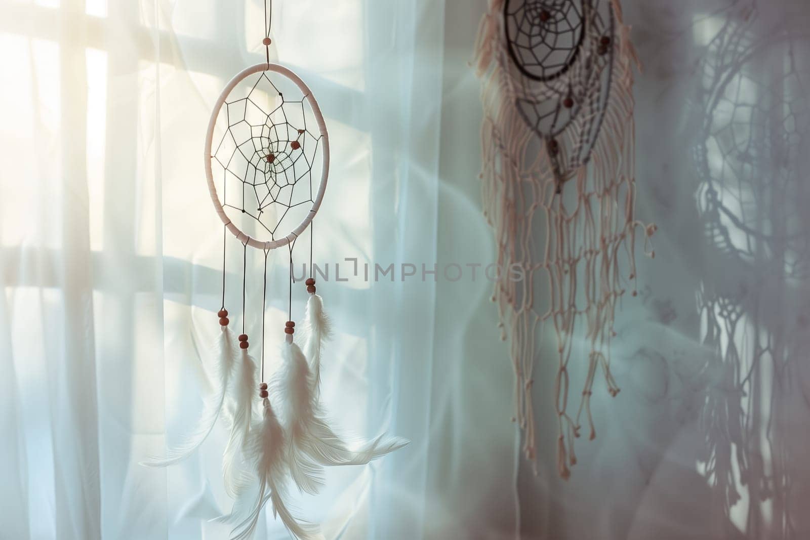 An organism made of wood and twigs, known as a dream catcher, hangs on a transparent glass circle in front of a window, blending art and visual arts