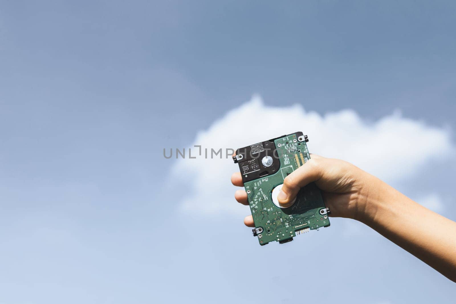 Recyclable electric waste held in hand up on sky background. Hand holding electronic trash for recycle reduce and reuse concept to promote clean environment with recycling management. Gyre