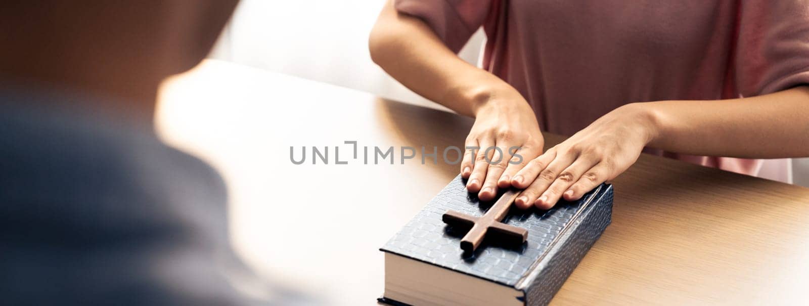 Close-up women prayer deliver holy bible book and holy cross to male believer. Spreading religion symbol. Concept of hope, religion, christianity and god blessing. Warm background. Burgeoning.