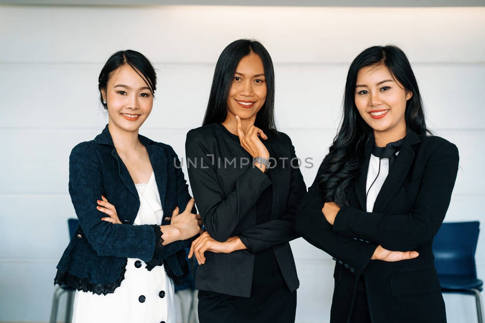 Young Asian businesswomen standing in office. uds by biancoblue