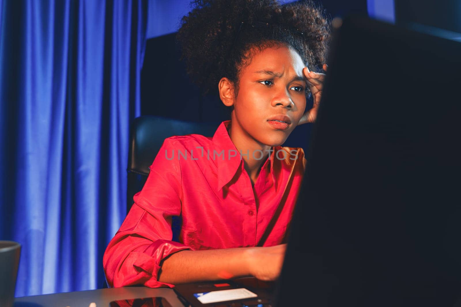 African woman businesswoman or blogger wearing pink shirt with serious face, looking and focusing on screen laptop with struggle project. Concept of stressful expression at work from home. Tastemaker.