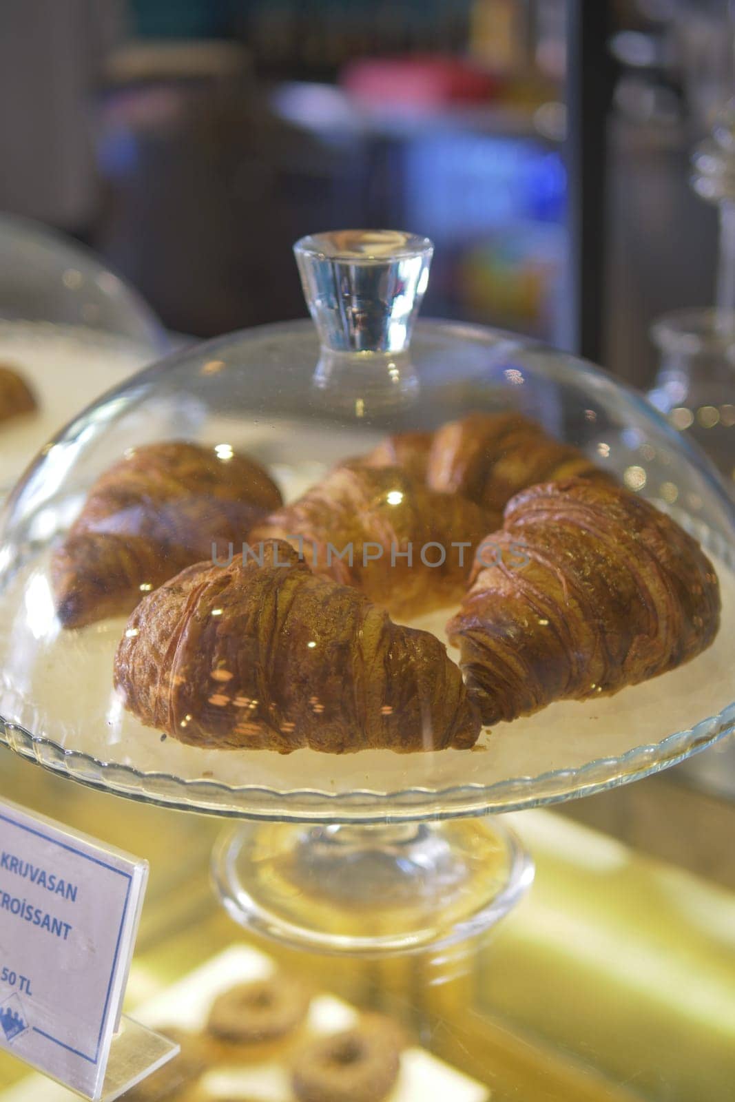 fresh baked croissant in a transparent jar at coffee shop .