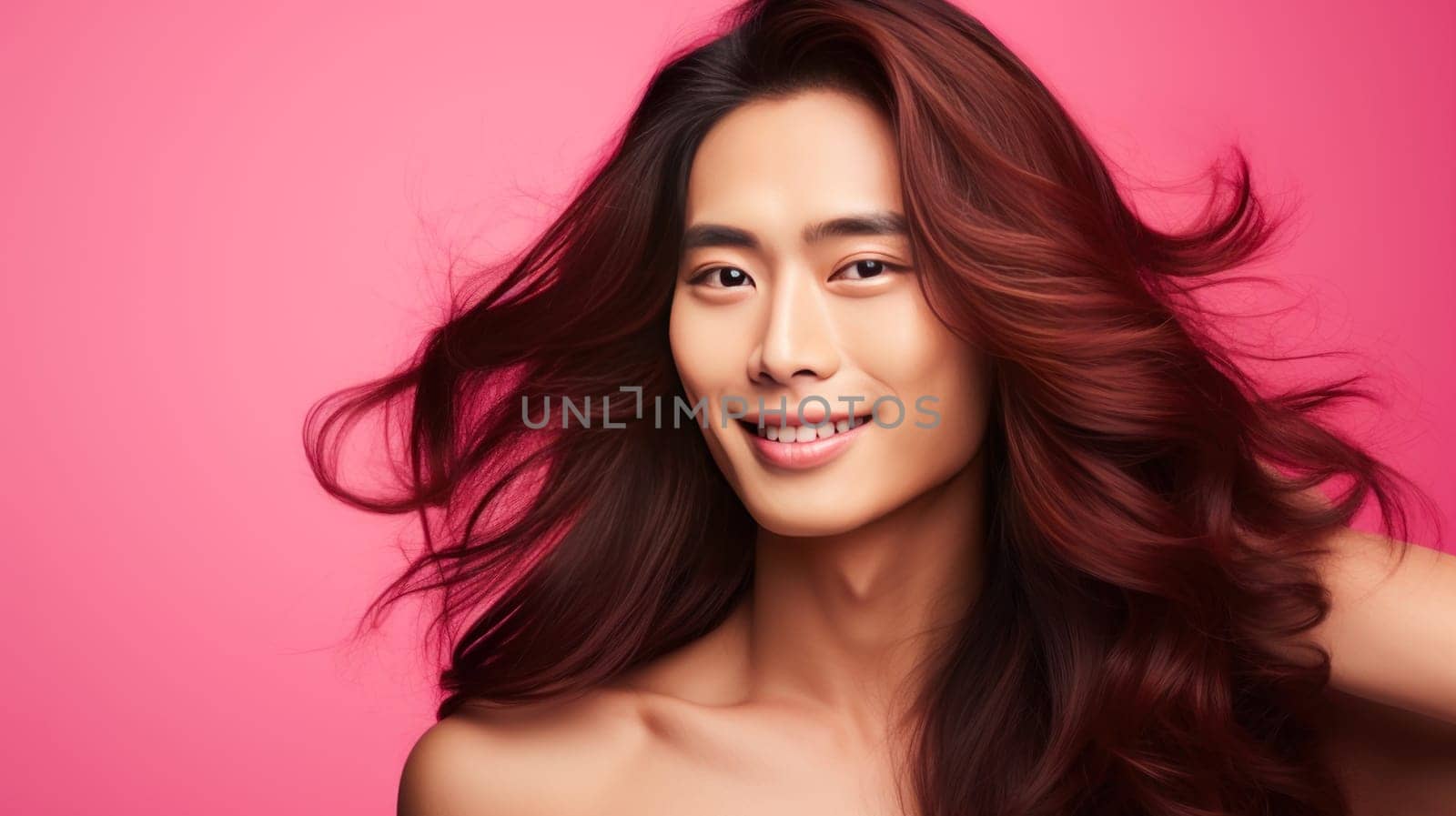 Handsome young male guy smile Asian with long red hair, on pink background, banner, copy space, portrait. Advertising of cosmetic products, spa treatments, shampoos and hair care products, dentistry and medicine, perfumes and cosmetology for men