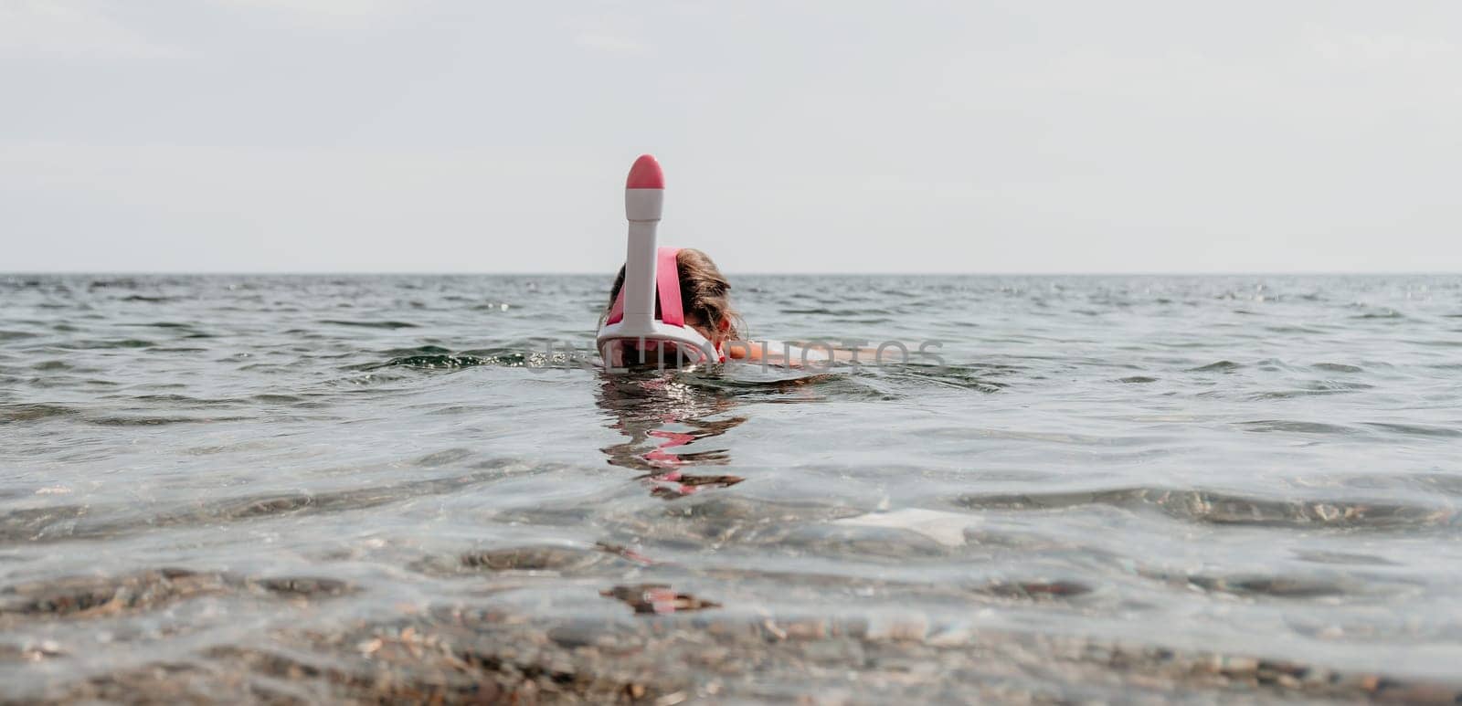 Young happy woman in white bikini put pink snorkeling mask on beach before swimming. girl having fun relaxing on beautiful beach. Beach lifestyle