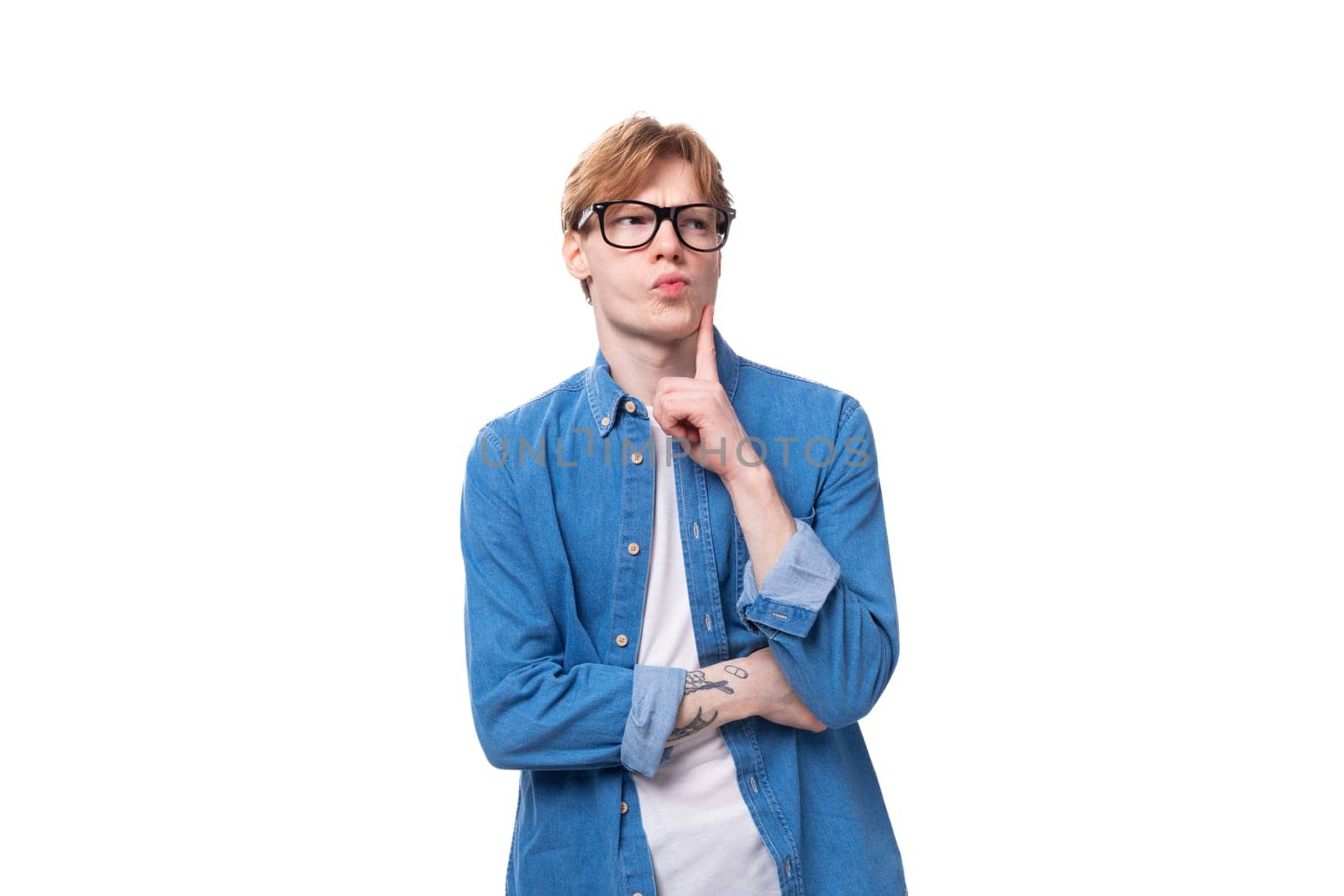 young smart european man with copper hair wears denim shirt is brainstorming.