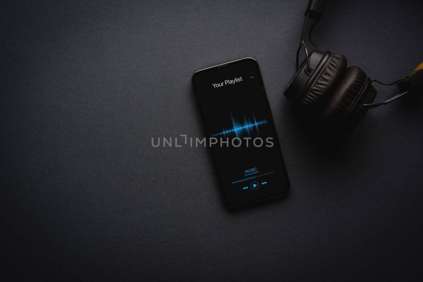 Smartphone with music player app on dark grey background by Sonat