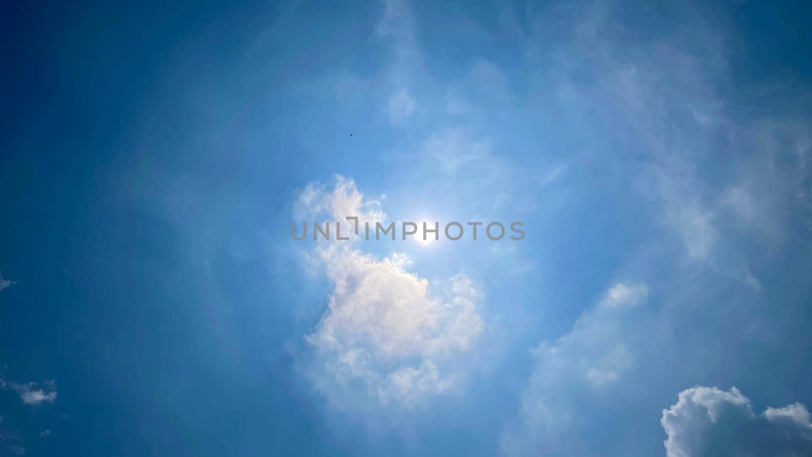 Heavenly white clouds on the blue sky with the sun appeared perfect for multimedia texture or background
