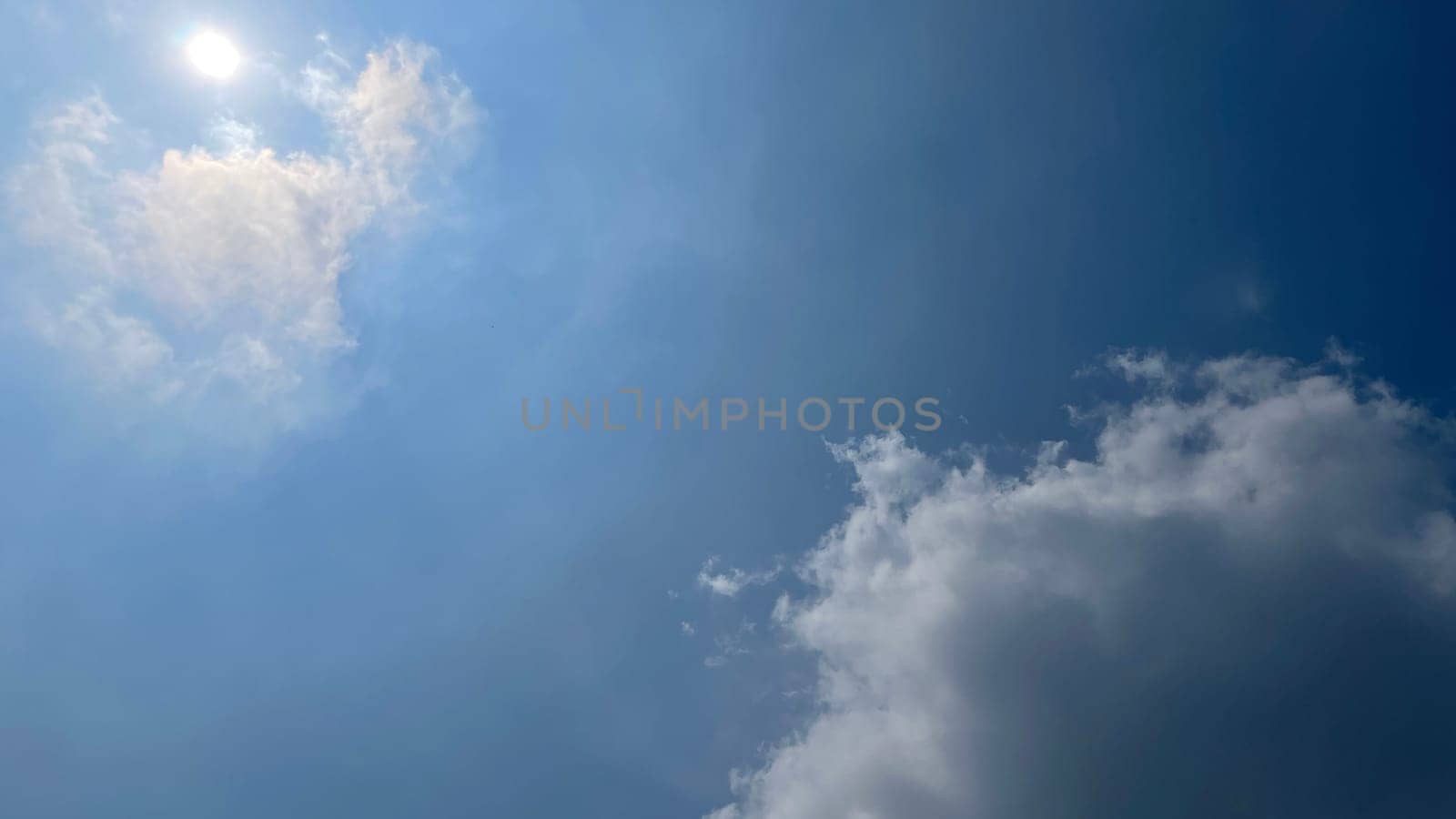 Heavenly white clouds on the blue sky with the sun appeared by antoksena