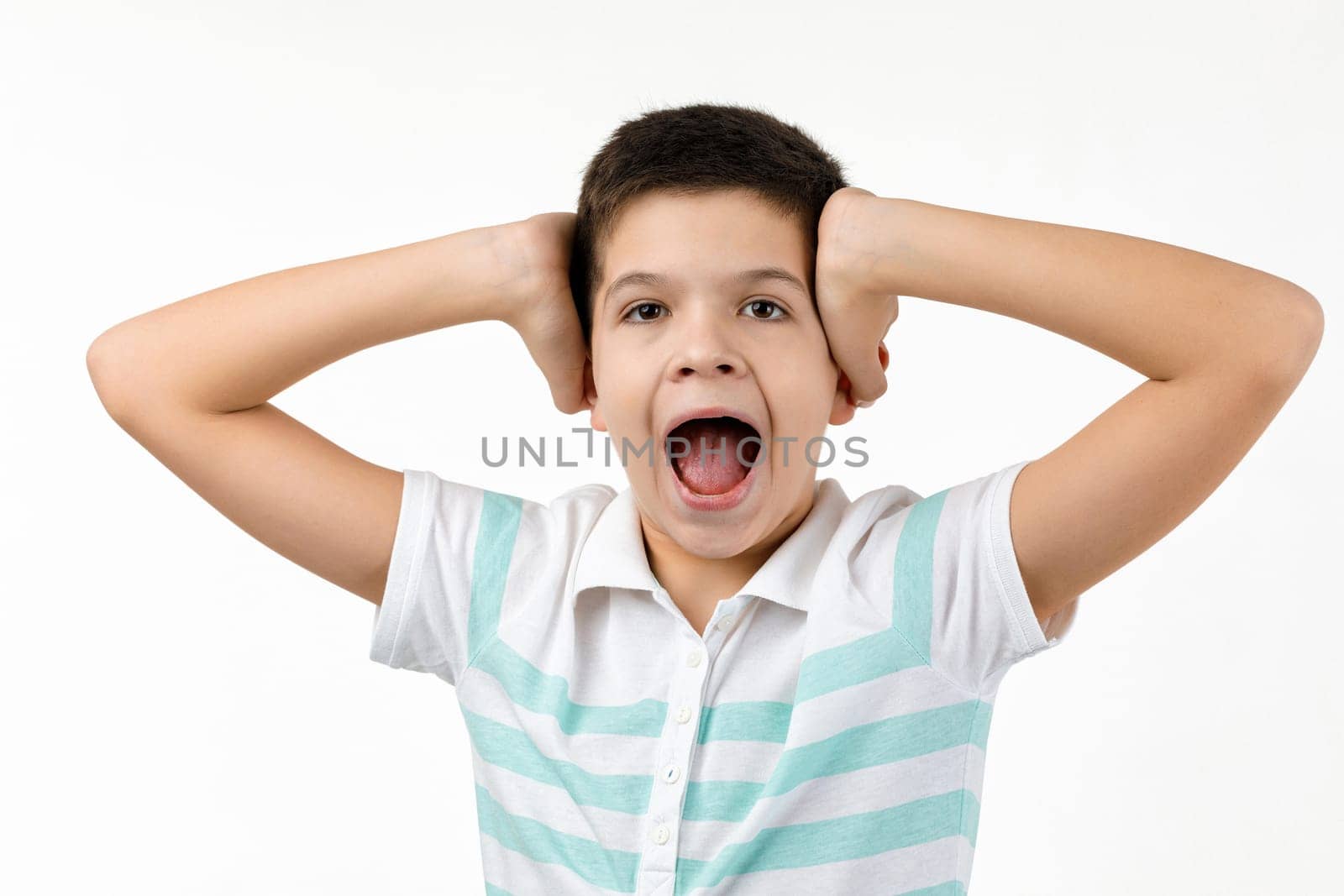 surprised shocked little child boy in t-shirt looking to camera on white background. Human emotions and facial expression