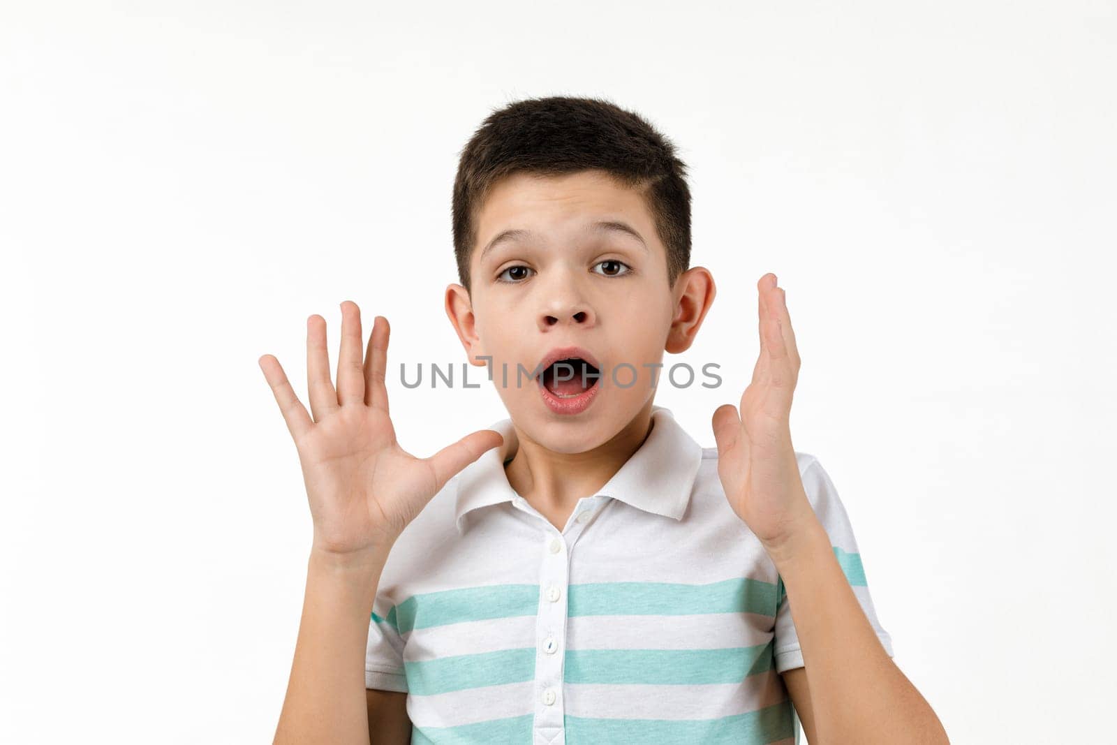 happy surprised little child boy in t-shirt looking to camera on white background. Human emotions and facial expression
