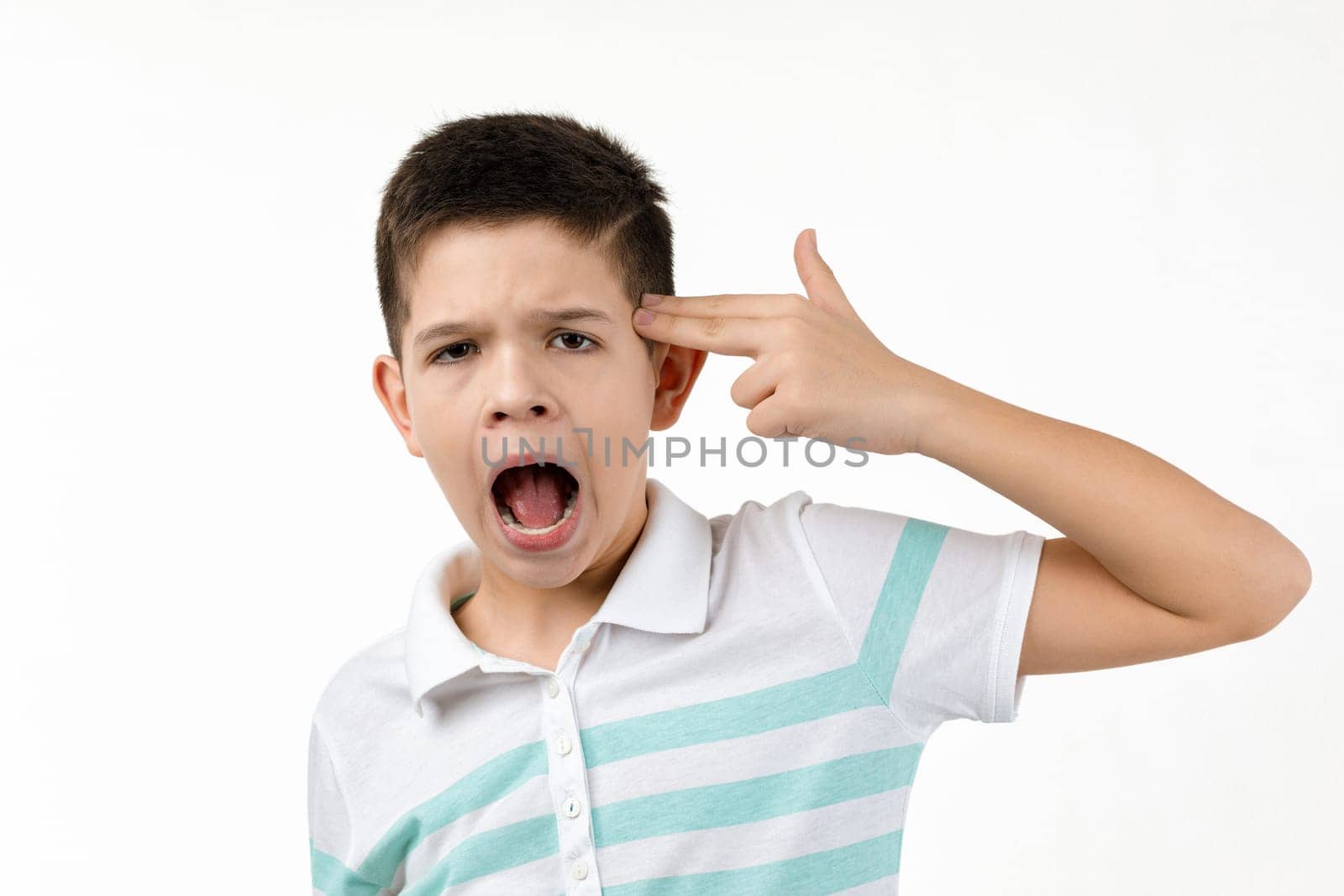 little boy in t-shirt shooting in temple with hand on white background.