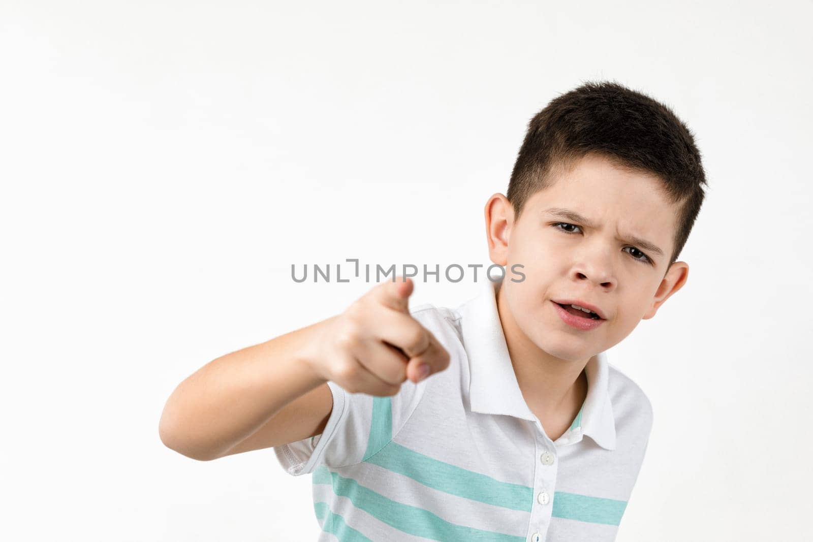 Cute little boy in striped t-shirt pointing camera on white background. child pointing at you.