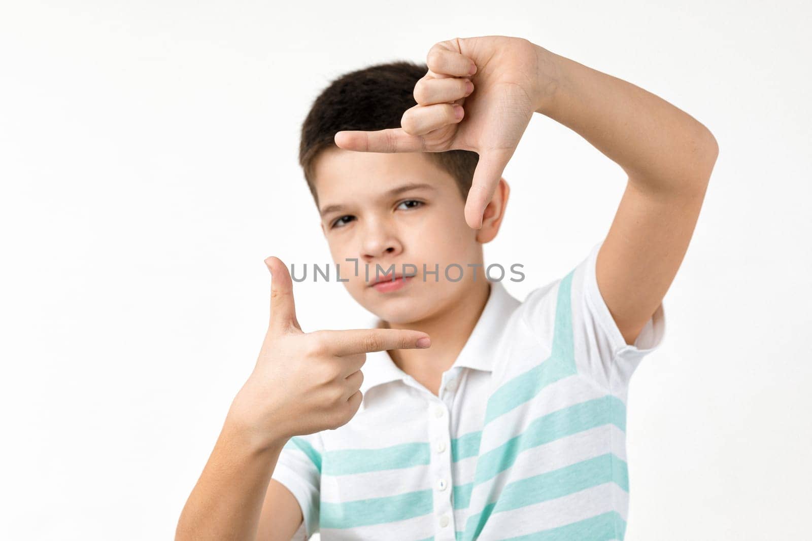 little child boy in striped t-shirt making hands photo frame gesture by erstudio