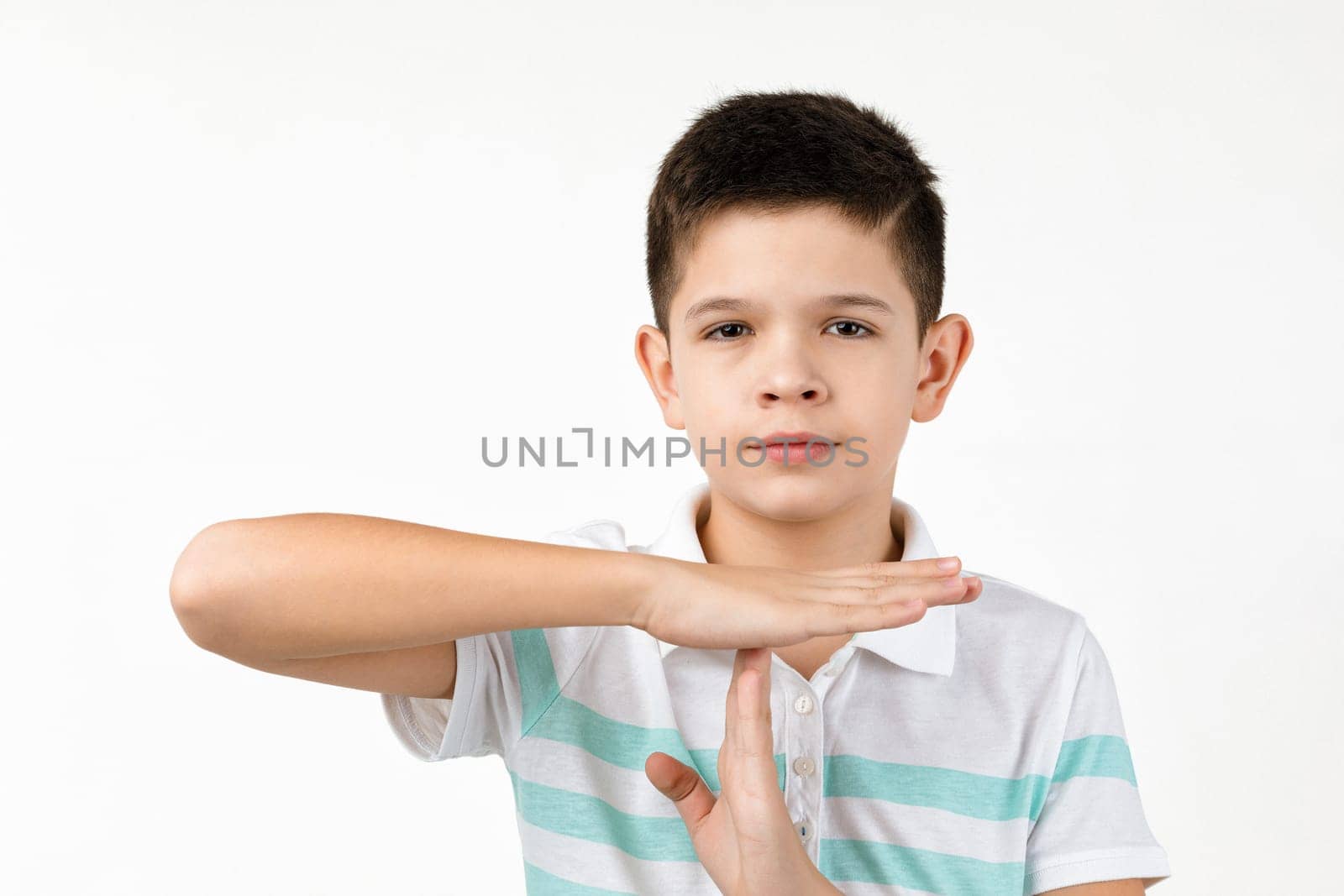 Cute little child boy in t-shirt making stop gesture on white background.