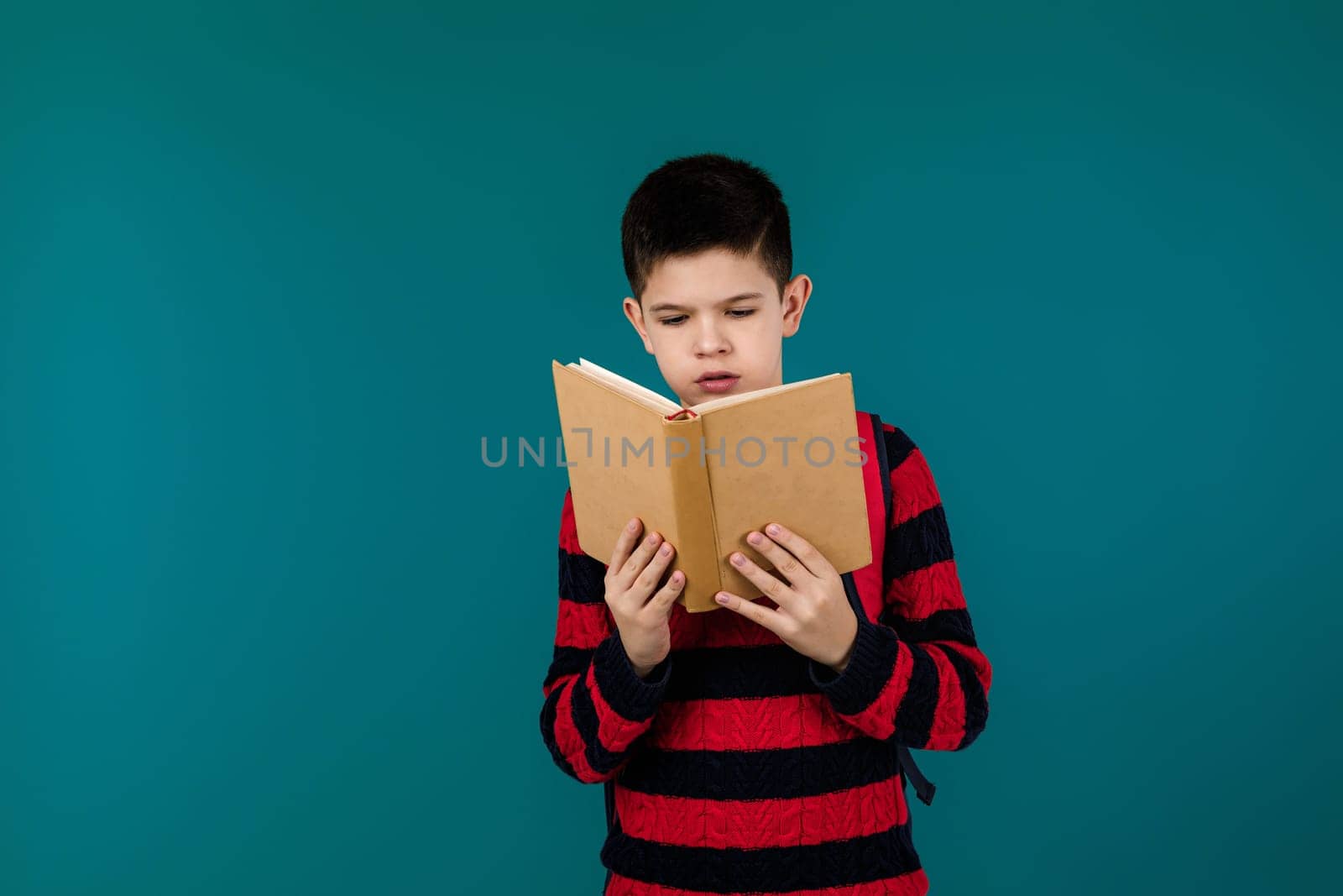 little cheerful school boy with book by erstudio