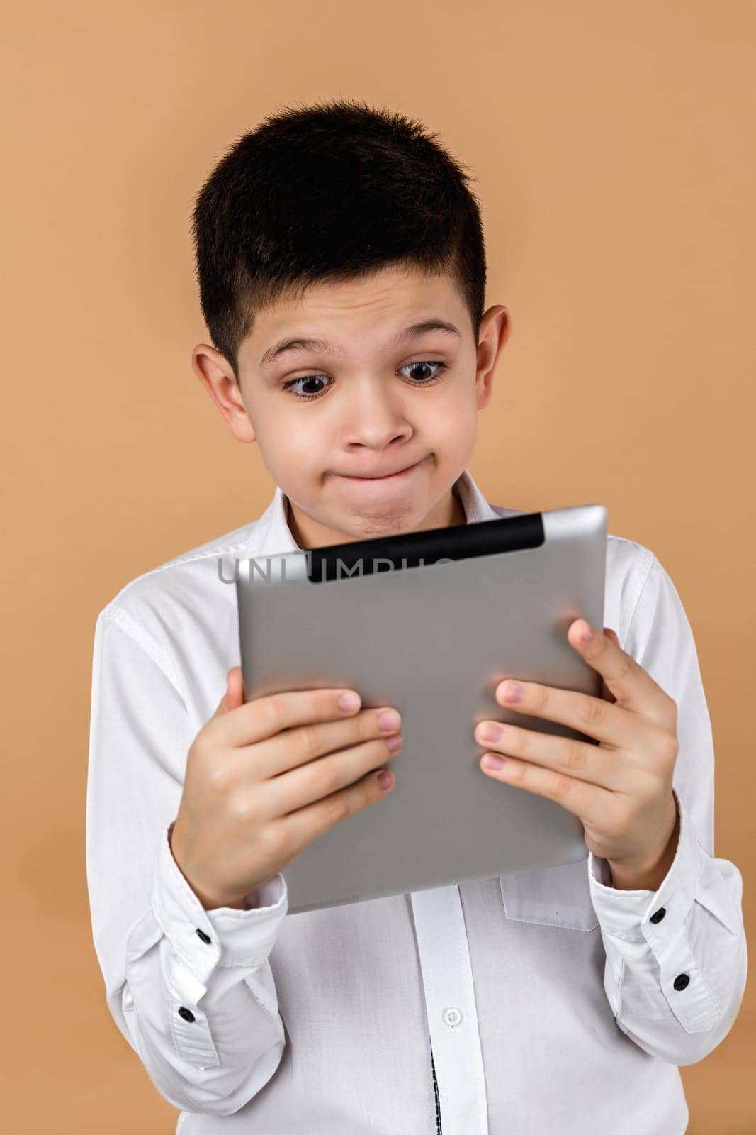 Little surprised boy using tablet by erstudio