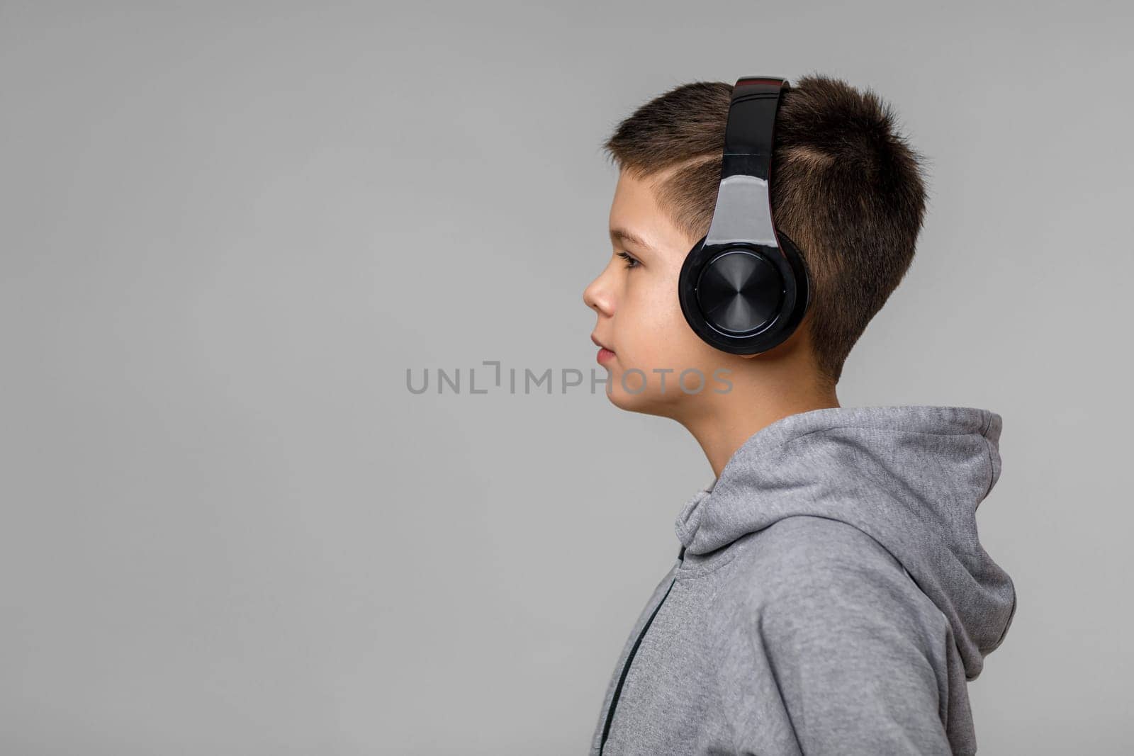 Happy child boy enjoys listens to music in headphones by erstudio