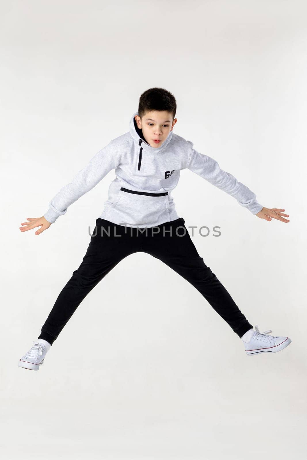 emotional little boy jumping on white studio background.