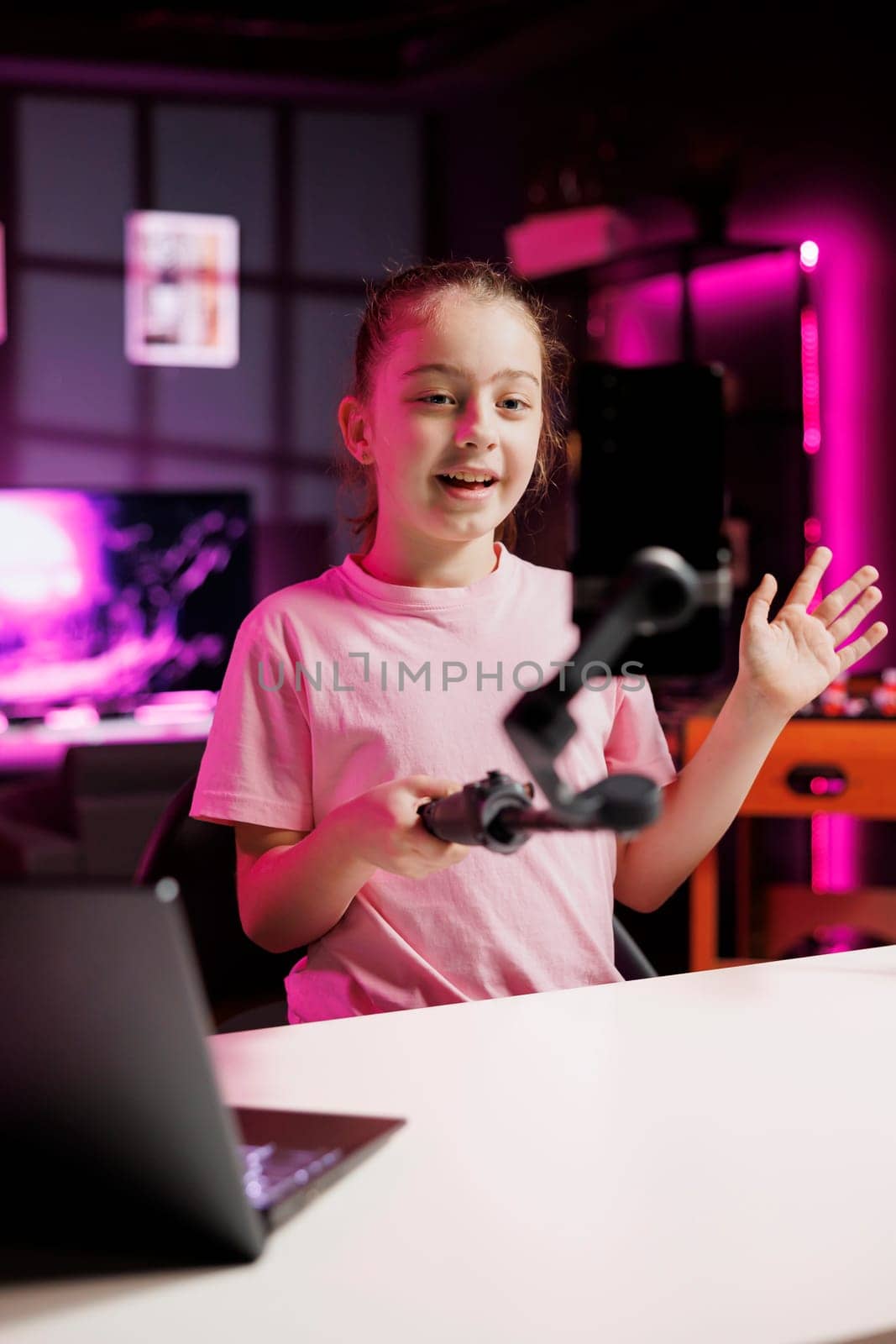Joyful generation Z influencer in pink neon home welcomes devoted children fan community by DCStudio