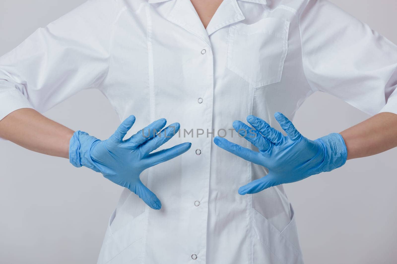 Woman doctor hands in medical latex blue gloves by erstudio