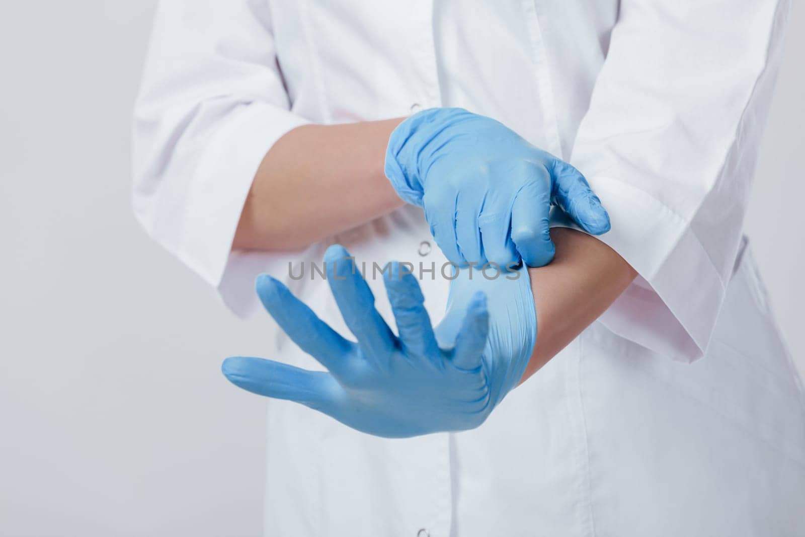 Woman doctor hands in medical latex blue gloves by erstudio