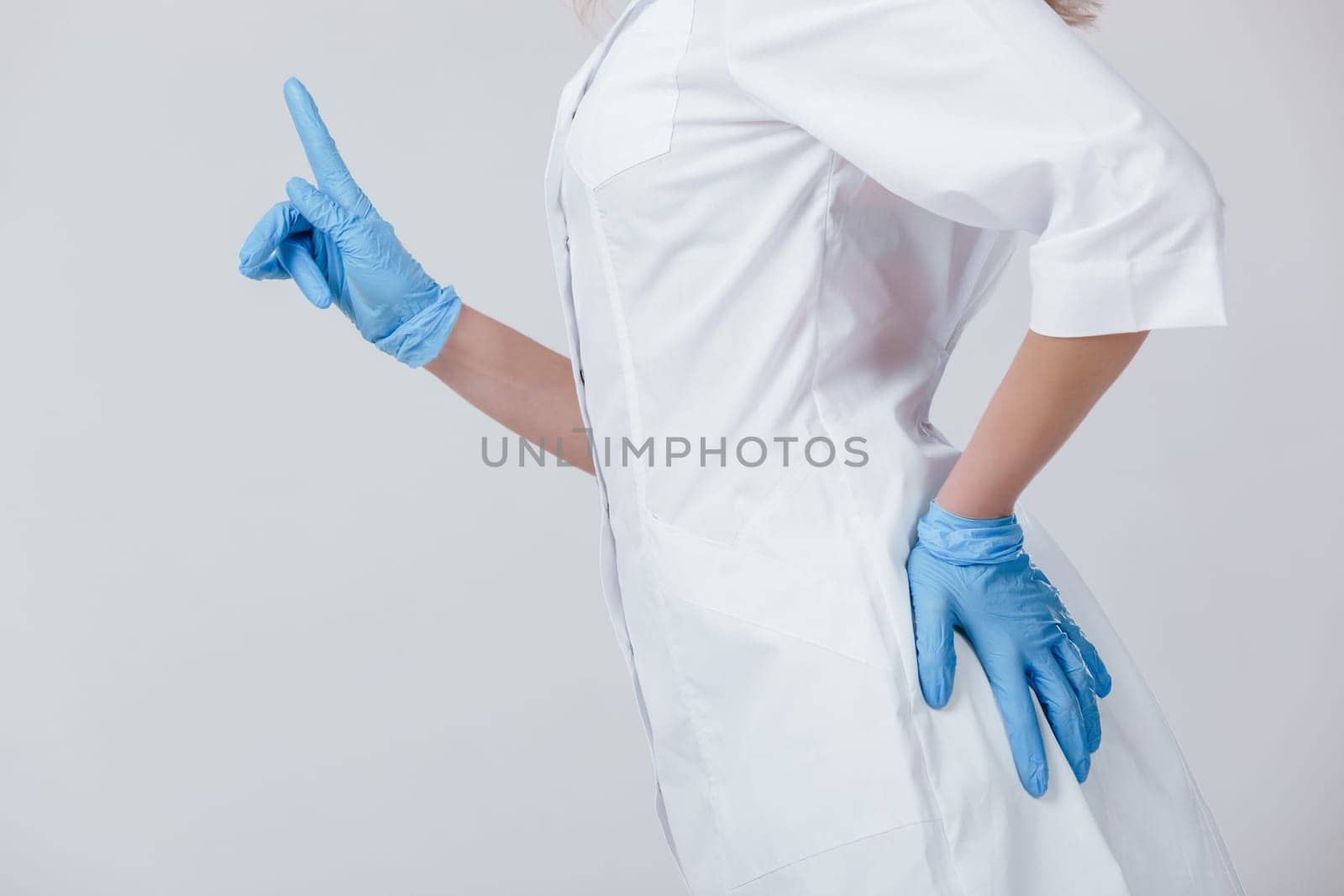 Woman doctor hands in medical latex blue gloves pointing on something