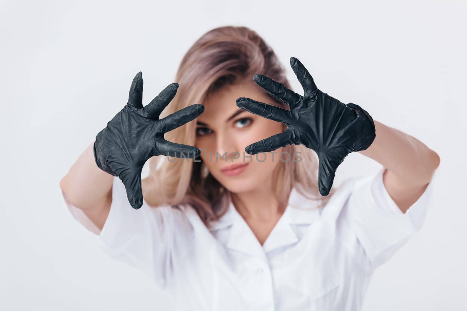 Portrait of woman doctor in black medical gloves shows stop sign