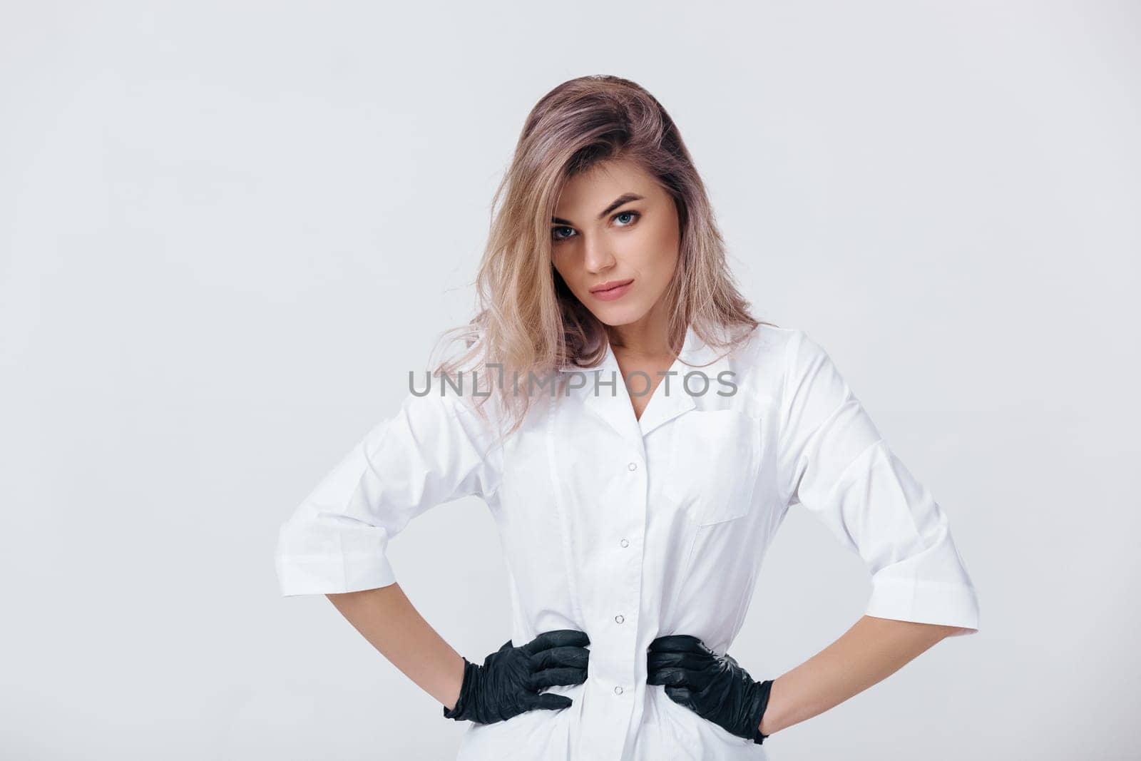 young female professional cosmetologist in black gloves. by erstudio