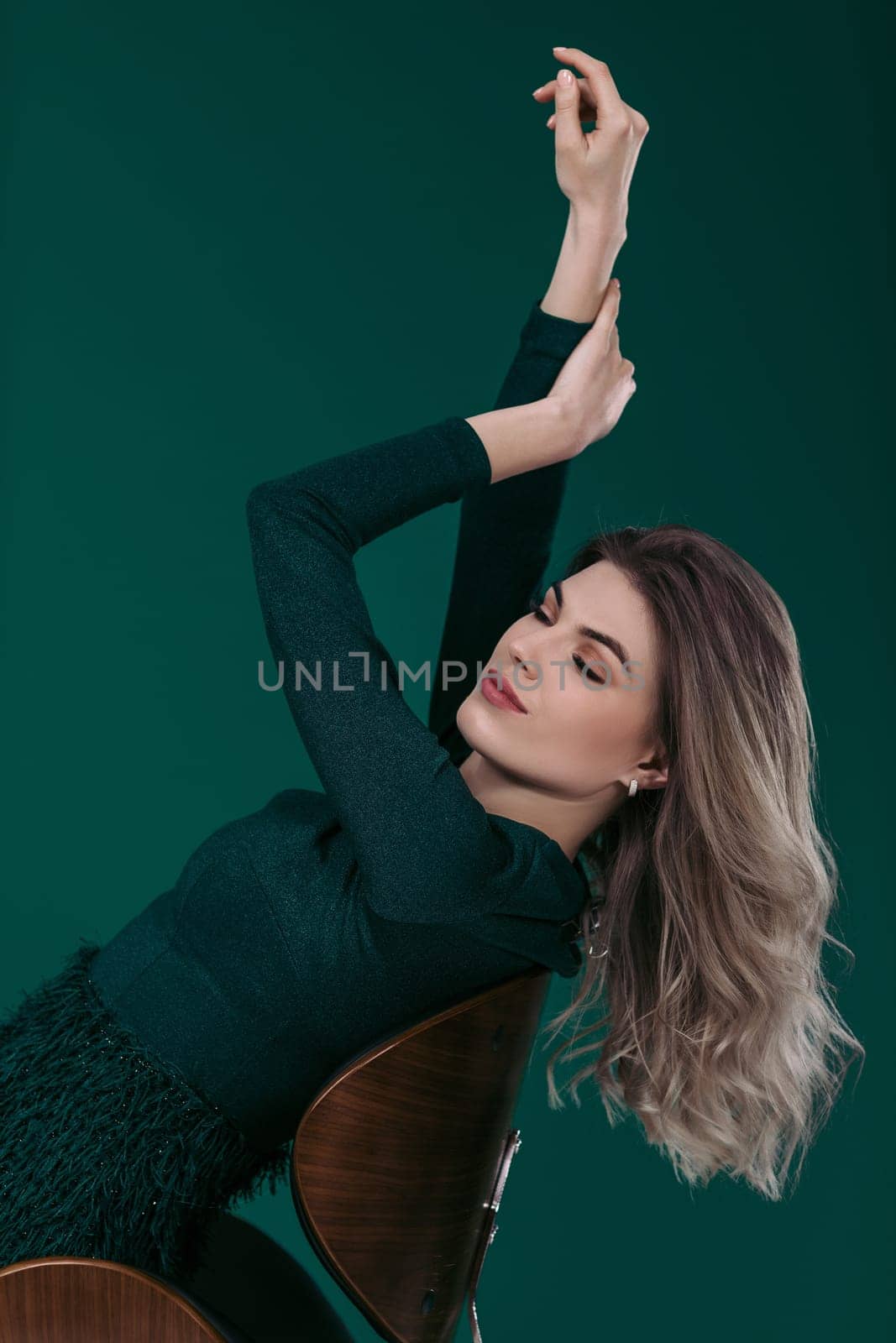 blonde woman posing in green dress on green background by erstudio