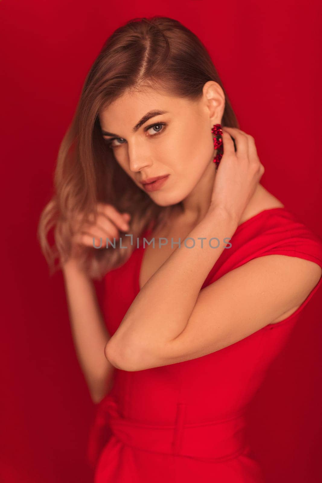 blonde woman posing in red dress on red background by erstudio