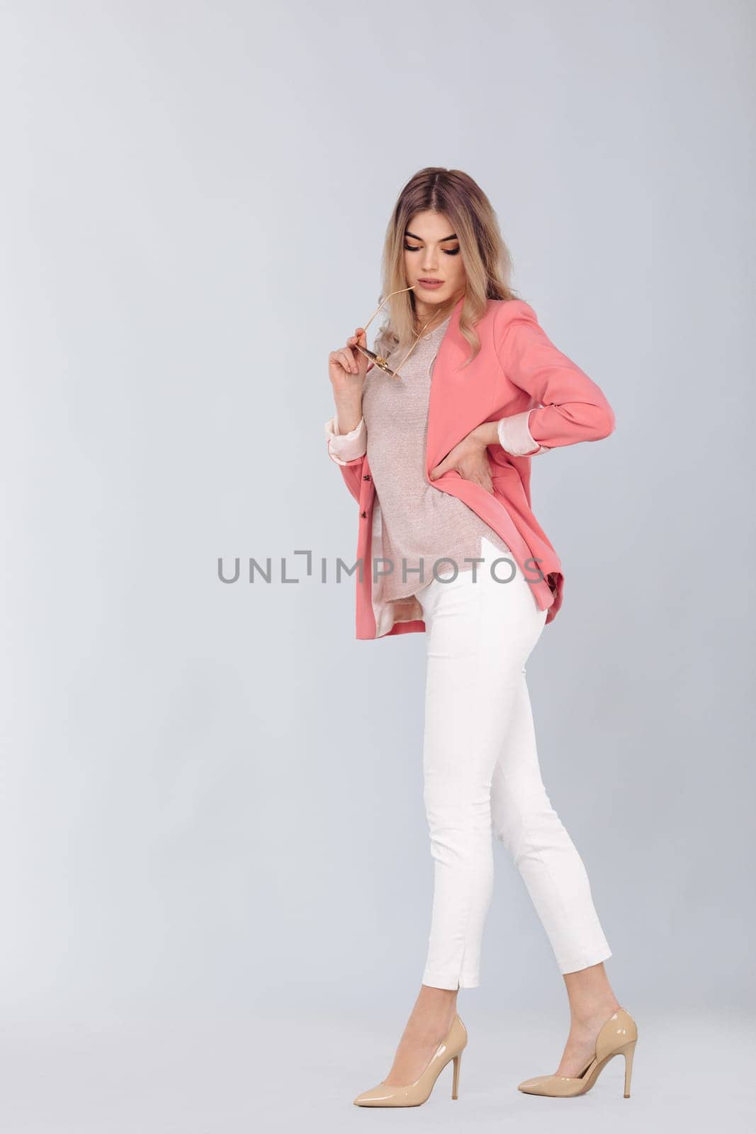 blonde woman in pastel casual jacket posing in studio. by erstudio