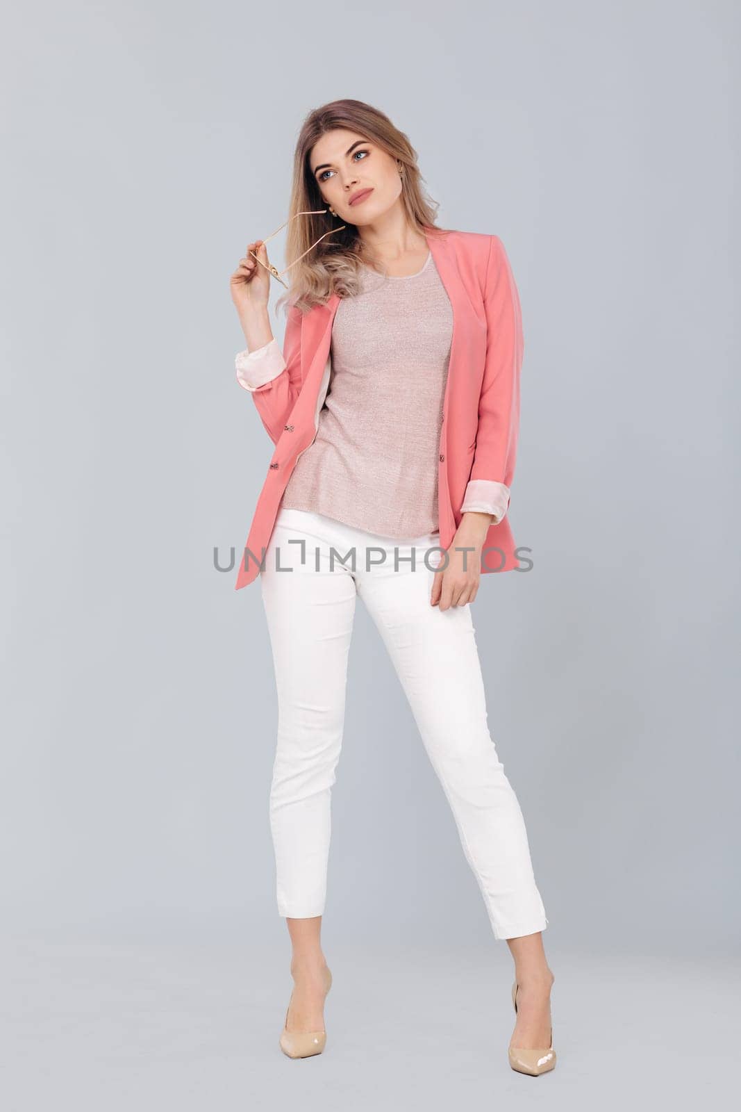 blonde woman in pastel casual jacket posing in studio. by erstudio