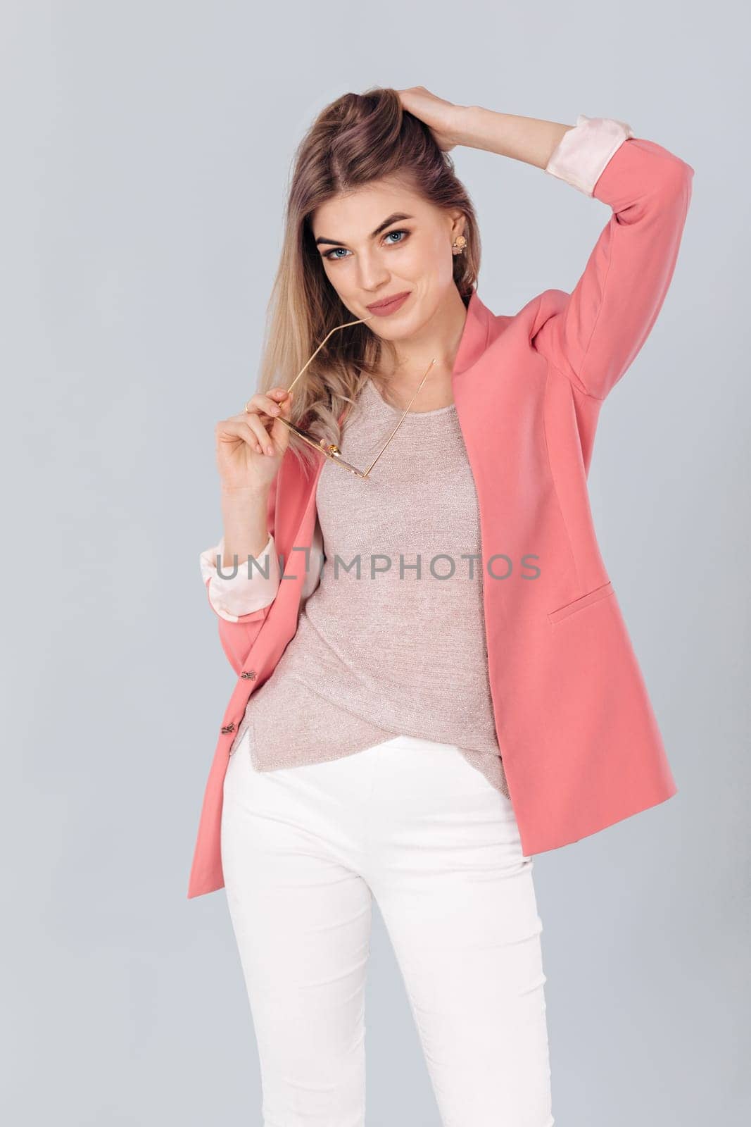 Fashion portrait of attractive elegant blonde woman in pastel casual pink jacket posing in studio. woman dressed in trendy spring outfit