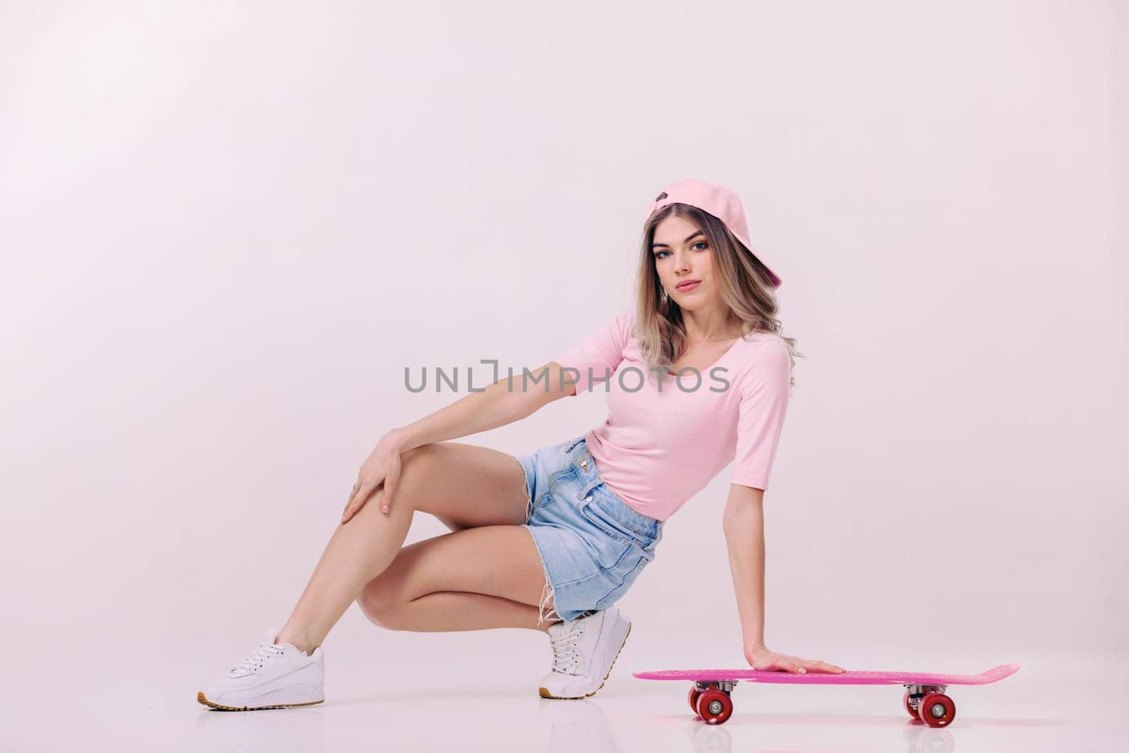 beautiful woman in white t-shirt with pink skateboard by erstudio