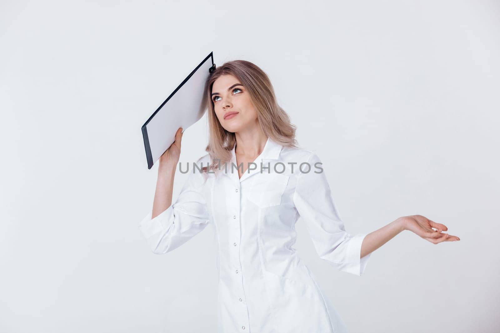 disappointed medical physician doctor woman in white coat holds folder and spreads her arms to the side