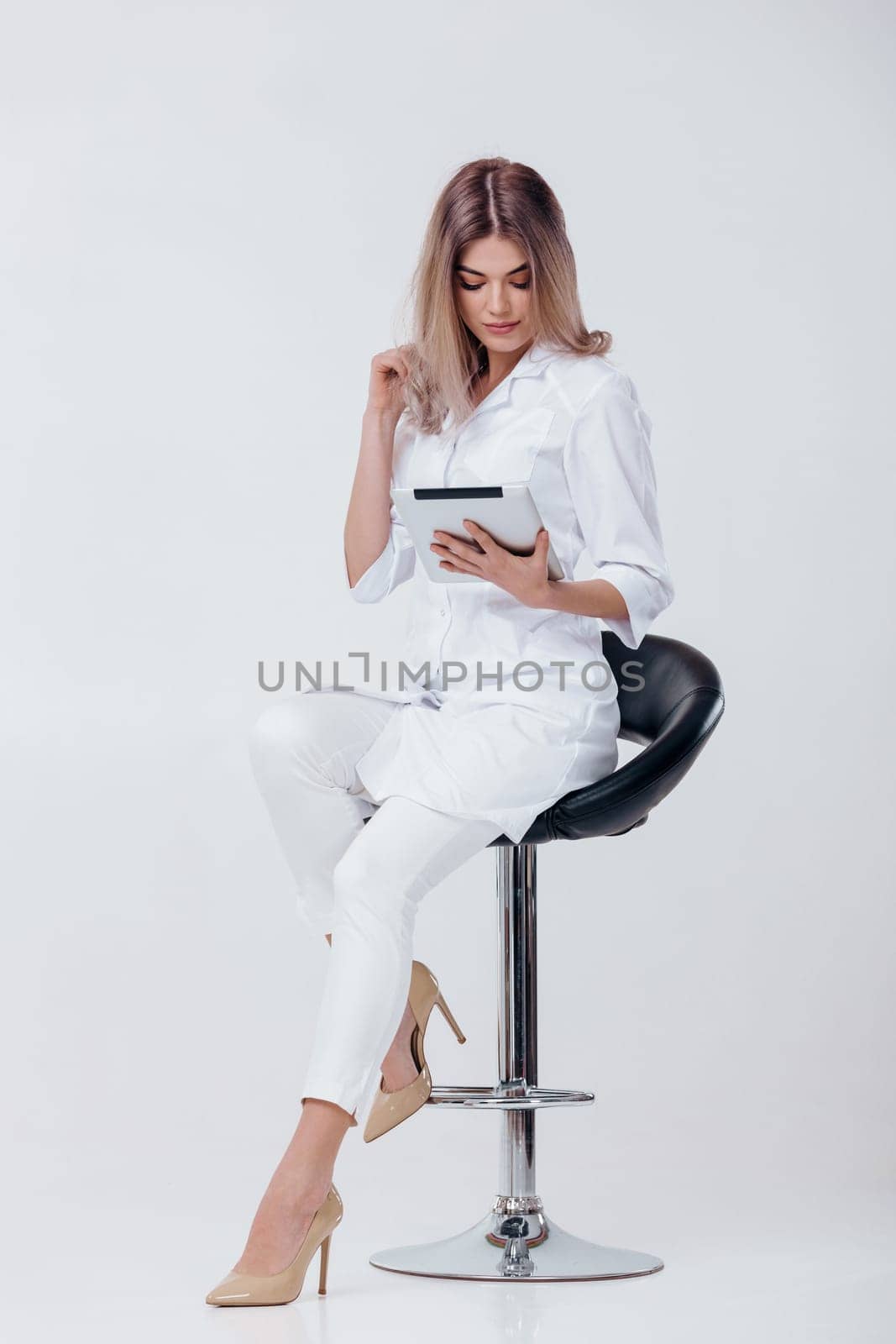 beautiful young doctor in white coat using digital tablet