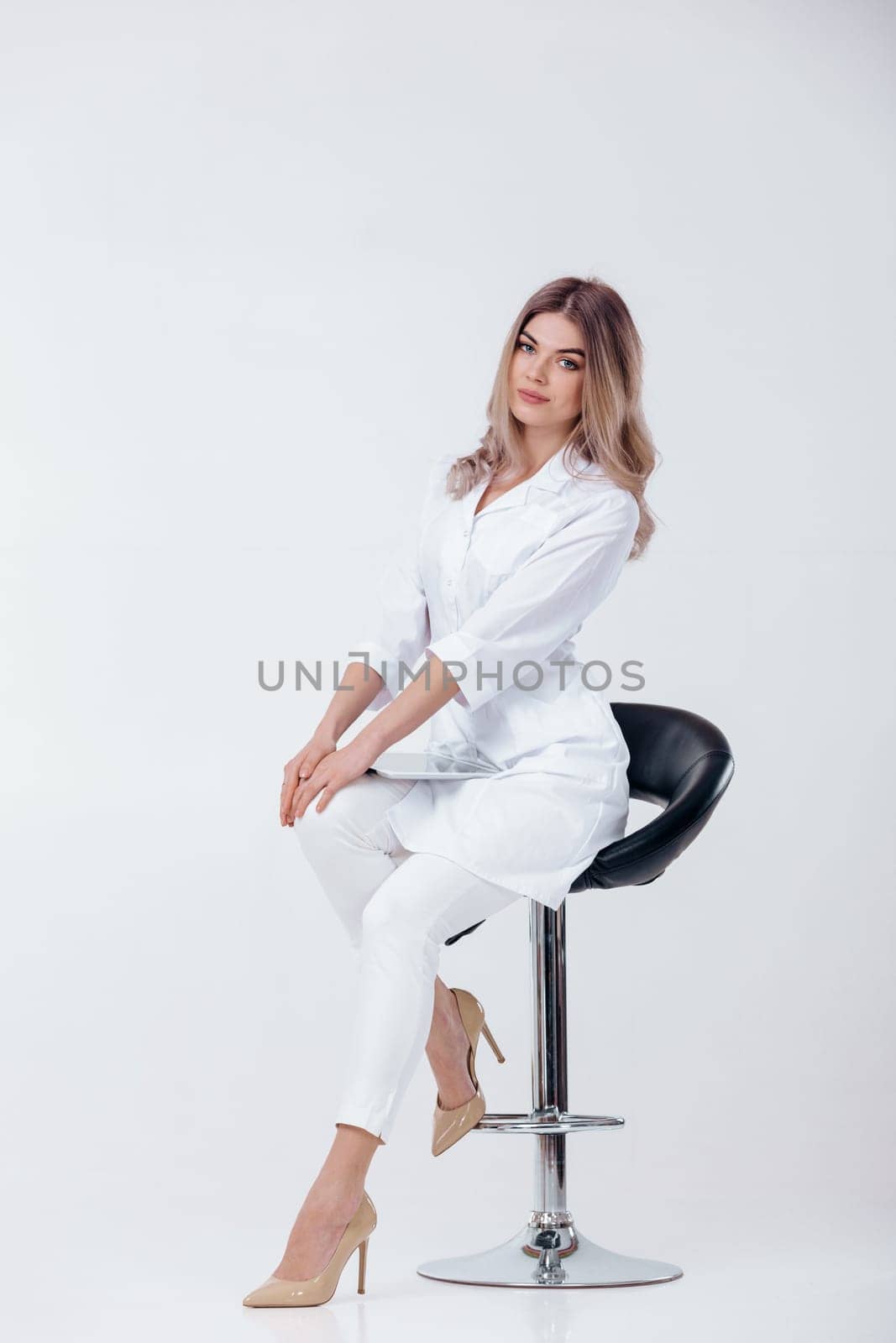 beautiful blonde doctor in white coat using digital tablet by erstudio