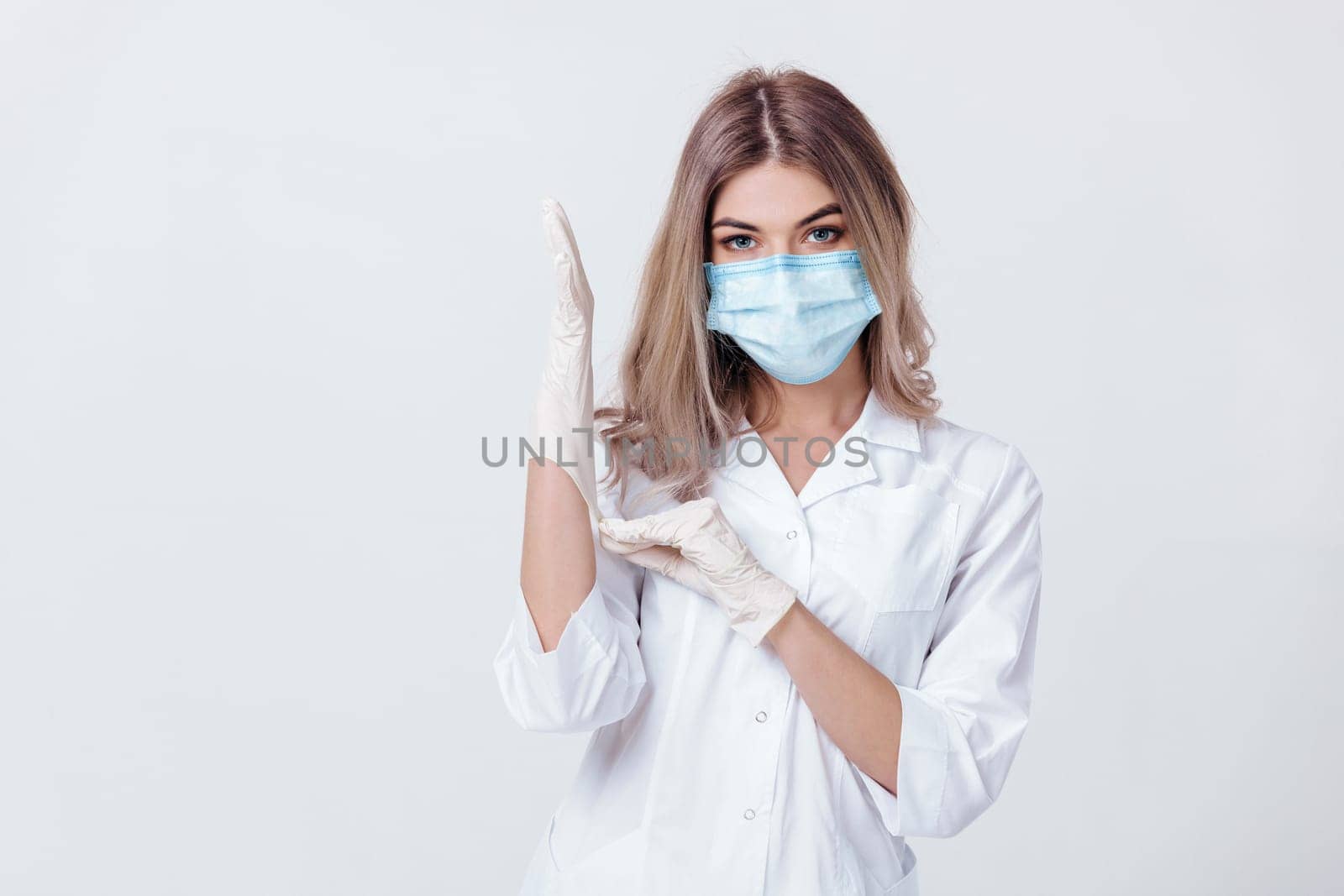 Portrait of woman doctor with face mask wearing white medical gloves