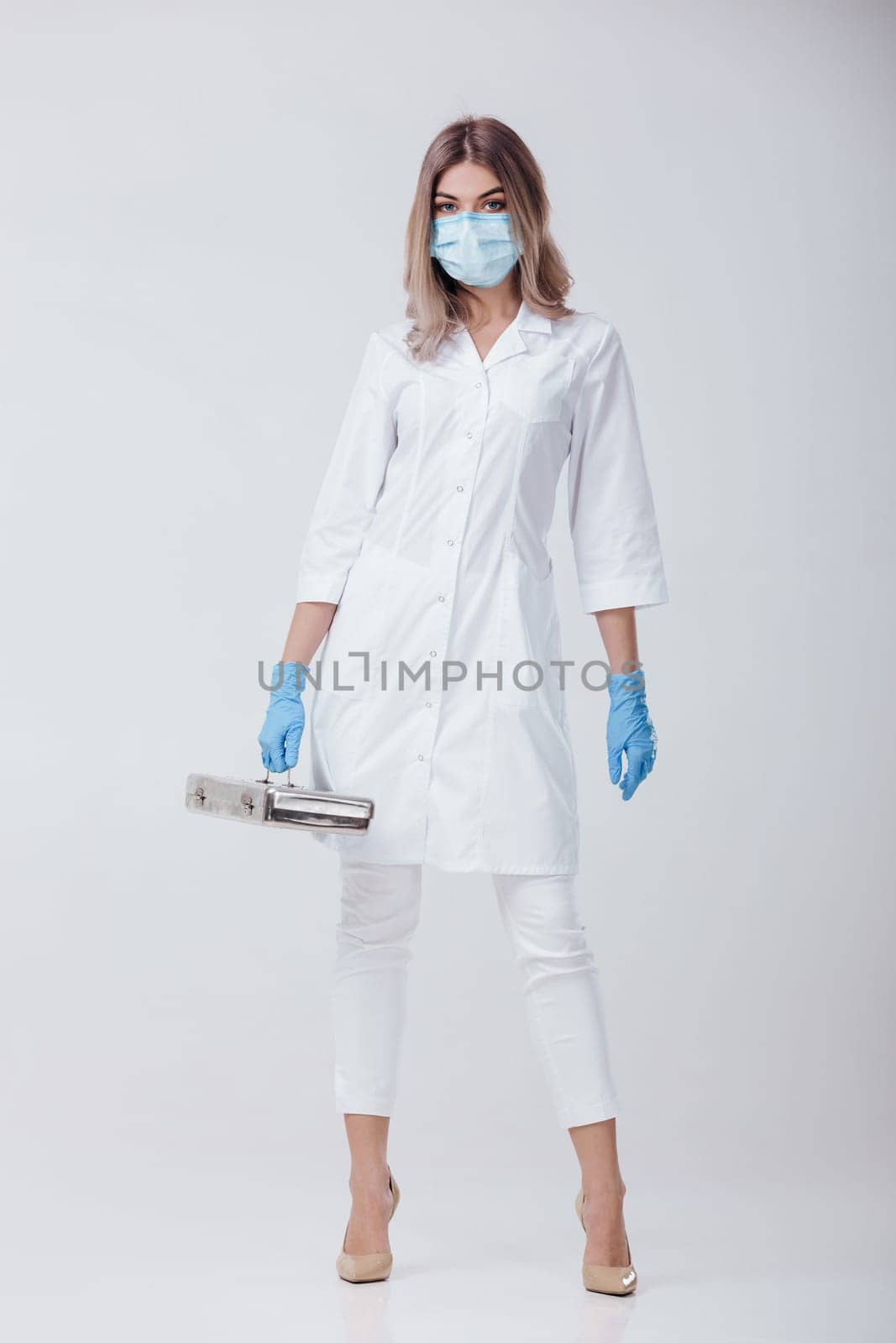 woman doctor with face mask and medical gloves by erstudio