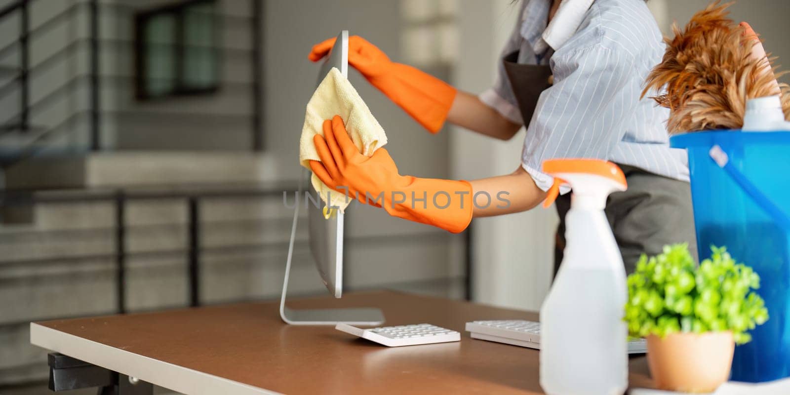 Woman clean in office room at office. Housekeeper or maid cleaner feel happy wipe mop and clean the work desk. the office office cleaning staff.