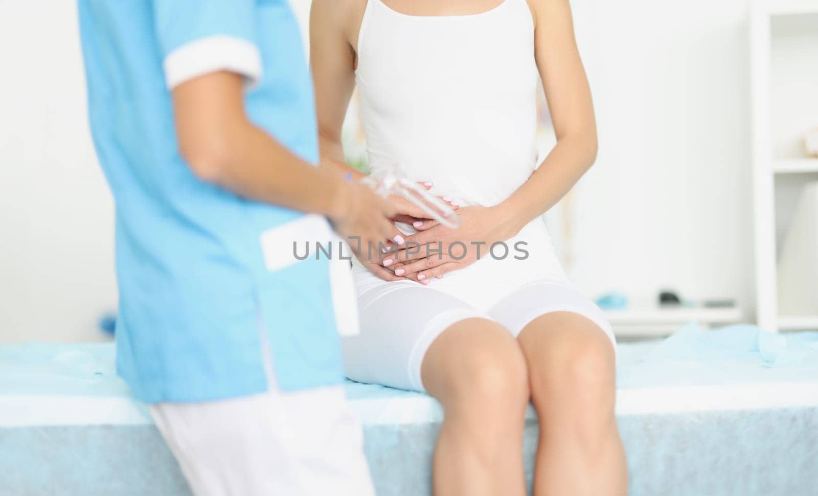 Gynecologist with medical instrument with mirror standing in front of woman with adnexitis. Ovarian cyst diagnosis concept