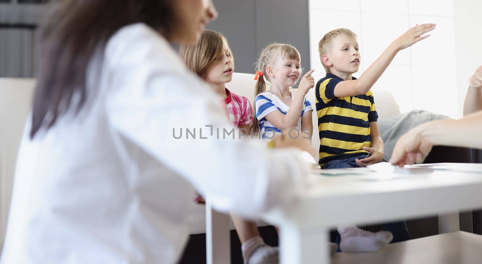 Children and parents playing board games at home. Family leisure concept