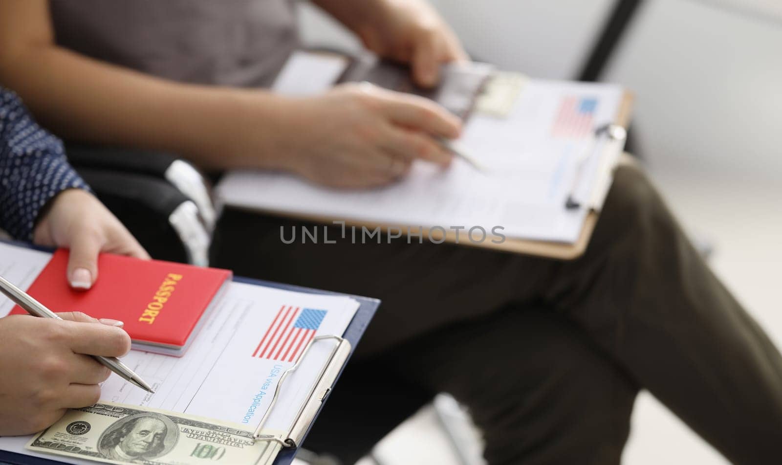 People sitting in line with documents for obtaining American visa and money closeup by kuprevich