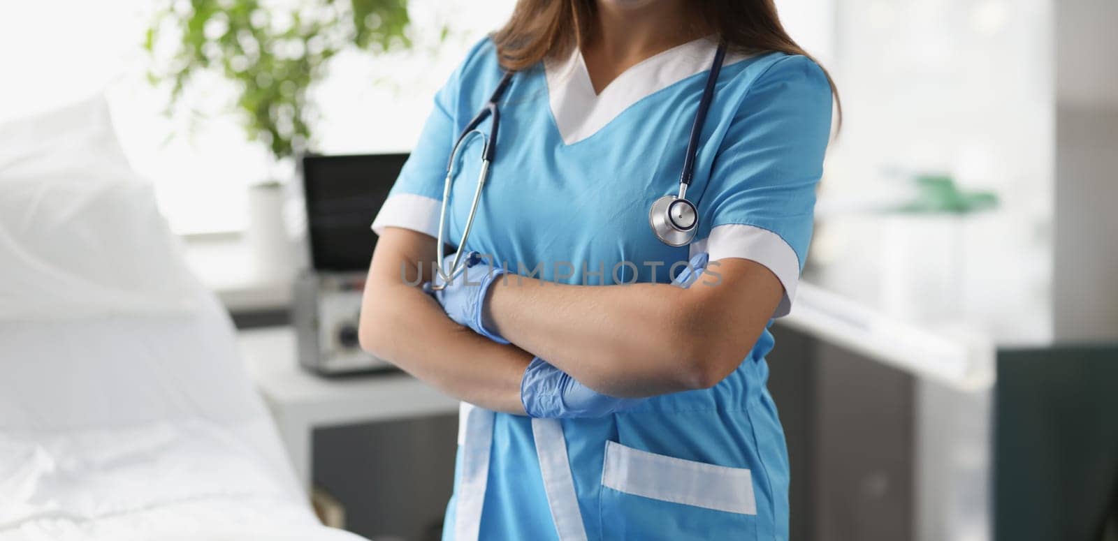 Woman doctor with crossed arms standing in hospital ward closeup by kuprevich