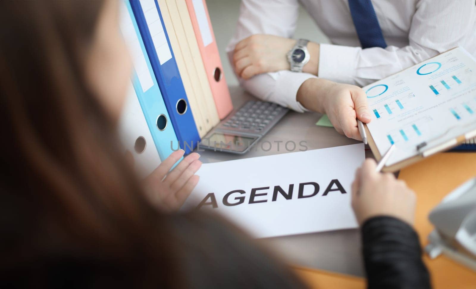 Man and woman sitting at table with documents with agenda closeup. Business meeting concept